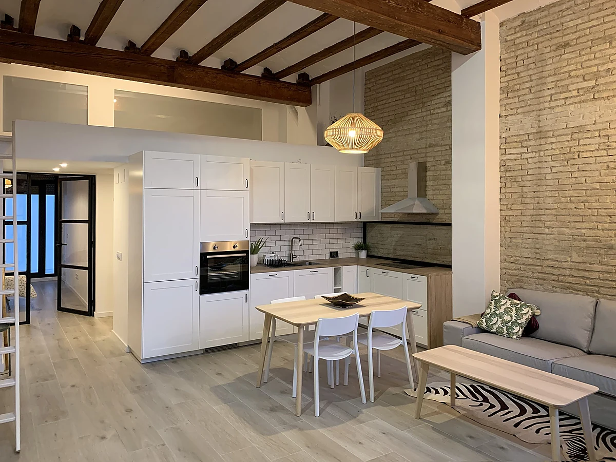 Cocina con vigas de madera y ladrillo visto de la Casa UM en Ciutat Vella, Valencia