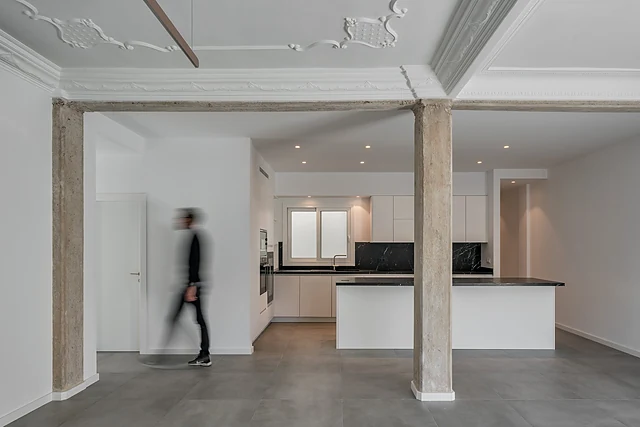 Planta diáfana con cocina abierta y pilares restaurados de la Vivienda KYP en Ciutat Vella, Valencia, reforma de Grupo Remodela